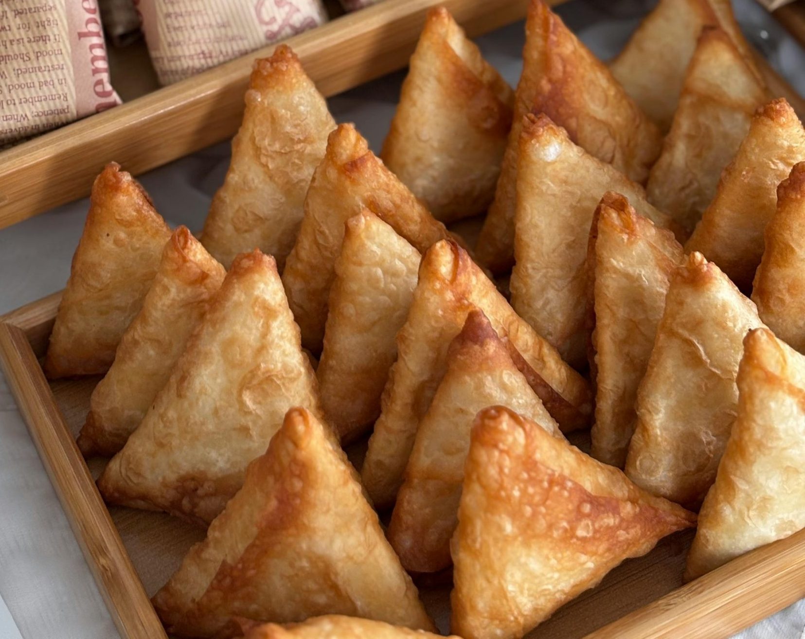 A tempting assortment of samosas and wraps with lettuce and cutlets, perfect for party appetizers.